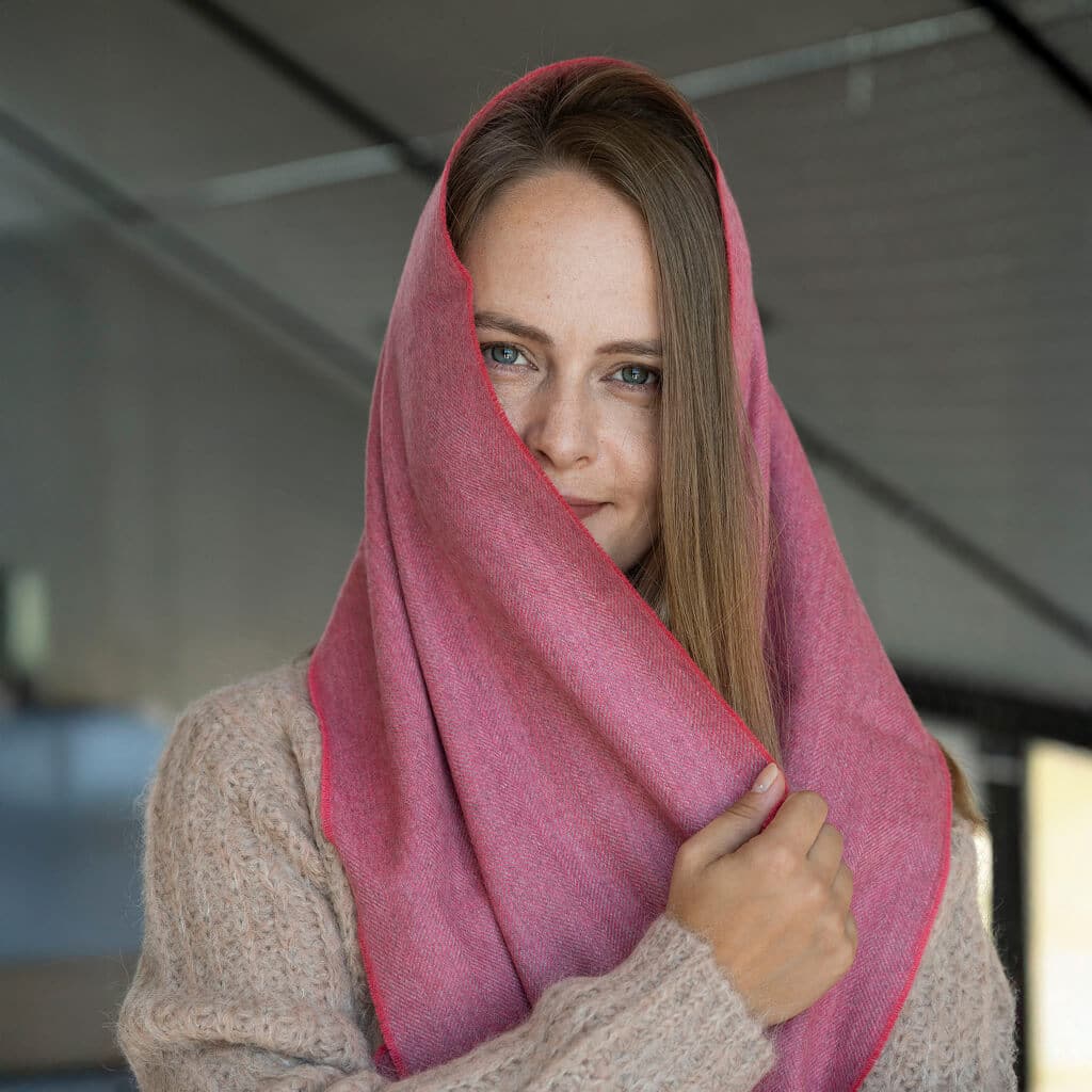 Frau mit weichem Babyalpaka Schal in pink, um ihren Kopf gewickelt