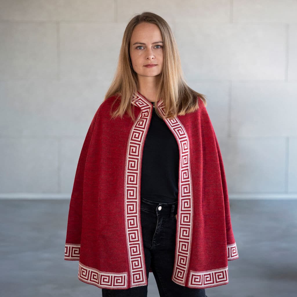 Frau in der Frontalaufnahme trägt den Alpaka Poncho Luz in rot