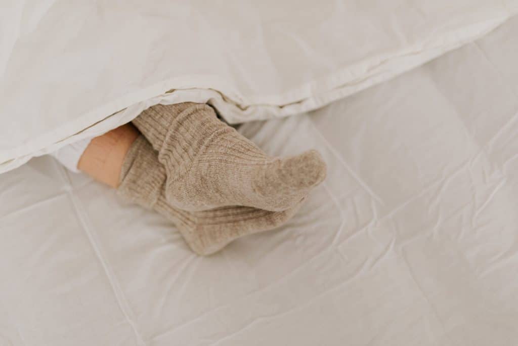Kuschelige Alpaka Schlafsocken im Bett getragen