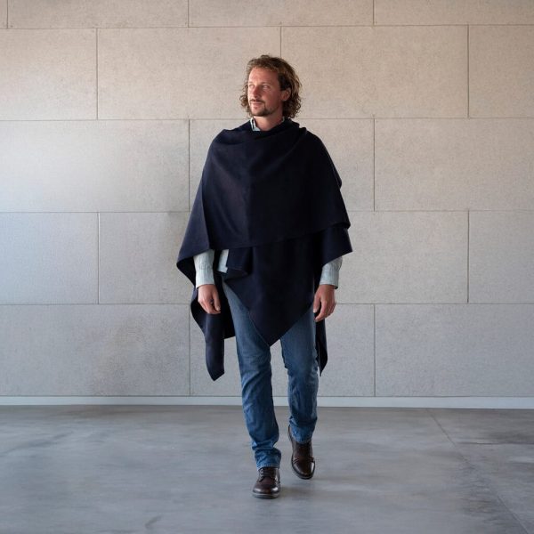 Mann beim Laufen mit der eleganten Tupac Alpaka Poncho Jacke in dunkelblau